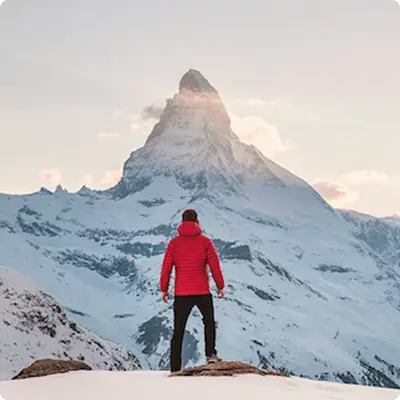 A man looking towards the peak of a mountain