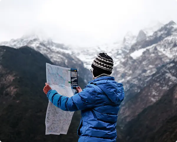 A man reading a map out in the mountains