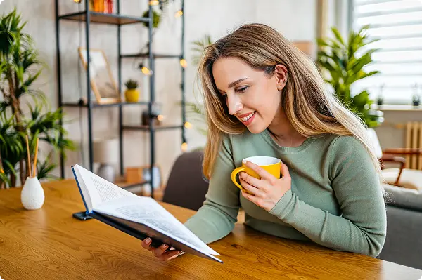 A woman reading the Field Guide while drinking coffee